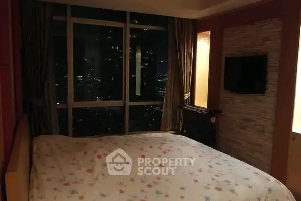 Cozy bedroom with city view, featuring large windows and modern decor, perfect for urban living.