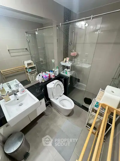 Modern bathroom with glass shower and sleek fixtures in a contemporary home.