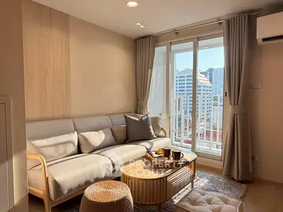 Chic living room with cozy sofa and city view balcony, perfect for urban living.