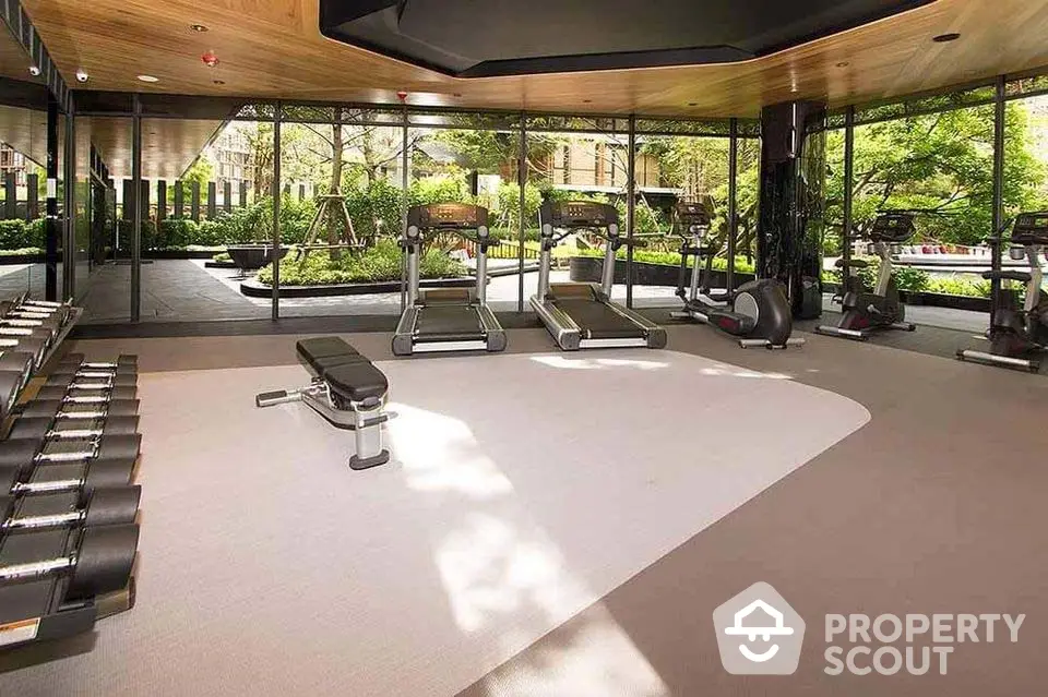 Luxurious gym with modern equipment and garden view in upscale residential complex