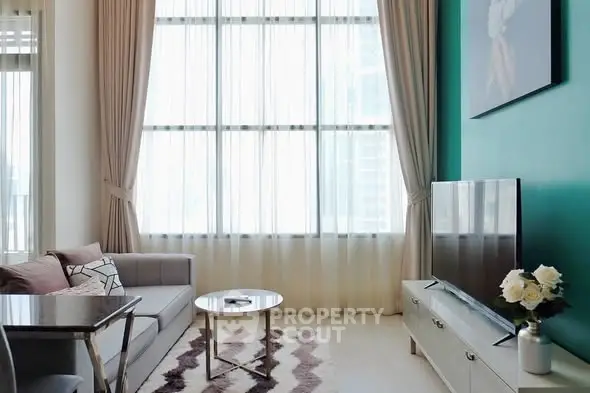 Modern living room with high ceilings, large windows, and stylish decor.