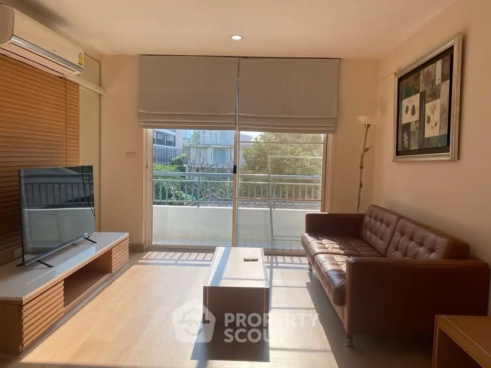 Bright living room with modern furniture and balcony view, perfect for relaxation and entertainment.