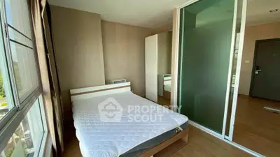 Modern bedroom with large window and sliding glass door, featuring a comfortable bed and sleek design.