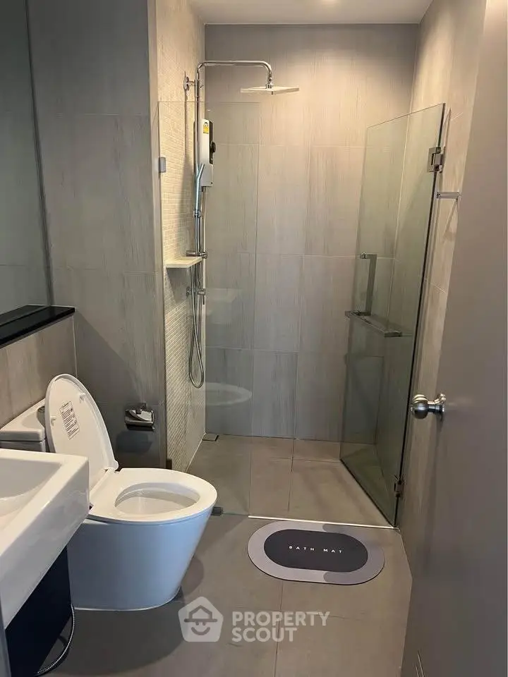 Modern bathroom with sleek shower and contemporary fixtures in a stylish apartment.