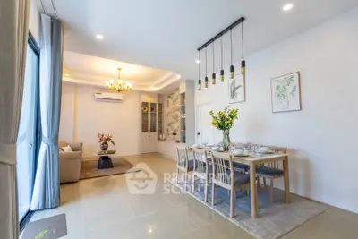 Spacious open-plan living and dining area with elegant decor and modern lighting.