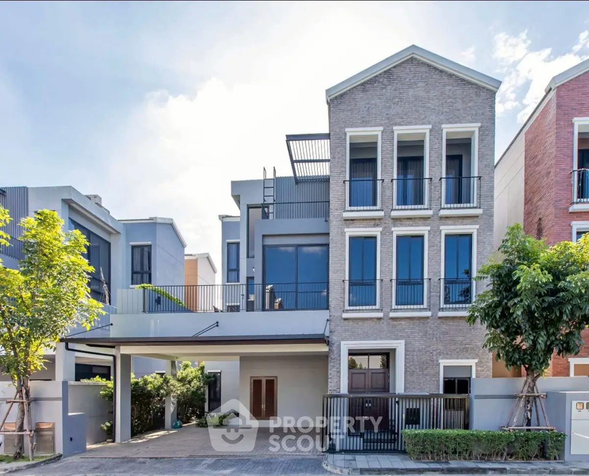 Modern multi-story house with large windows and a spacious driveway in a suburban neighborhood.