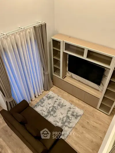 Modern living room with sleek TV unit and cozy sofa, perfect for relaxation.