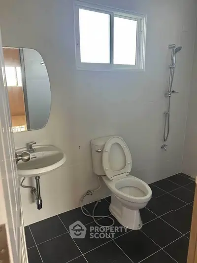 Modern bathroom with sleek fixtures and natural light from window.