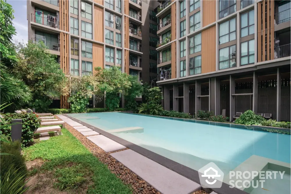 Modern condominium with serene pool and lush greenery, perfect for urban living.