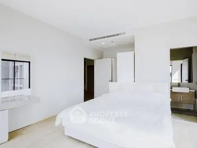 Bright and spacious bedroom with modern minimalist design and ensuite bathroom.