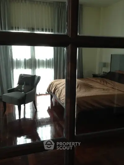 Cozy bedroom with elegant chair and large window for natural light