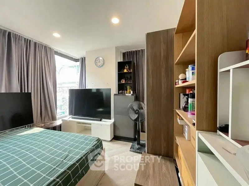 Modern bedroom with large windows and stylish decor in a cozy apartment.