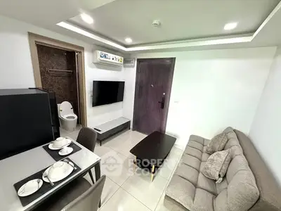 Modern living room with dining area and bathroom access, featuring sleek furniture and neutral tones.