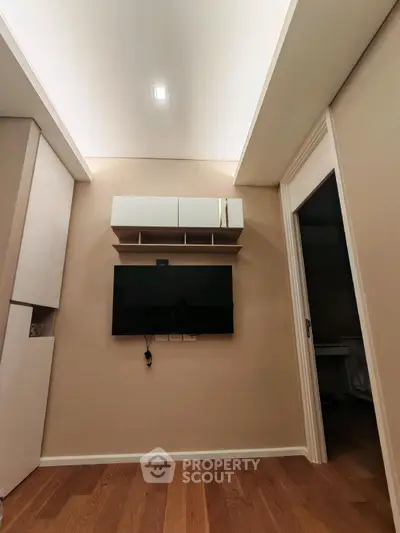 Modern living room with wall-mounted TV and sleek storage solutions.