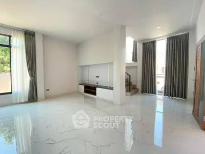 Spacious modern living room with marble flooring and large windows for natural light.