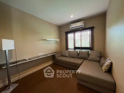 Cozy living room with modern sofa and air conditioning, perfect for relaxation.