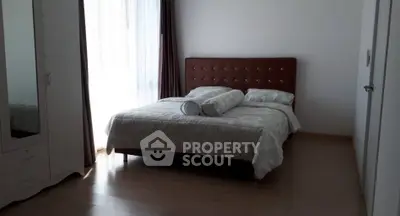 Cozy bedroom with elegant bed and ample natural light, perfect for relaxation.