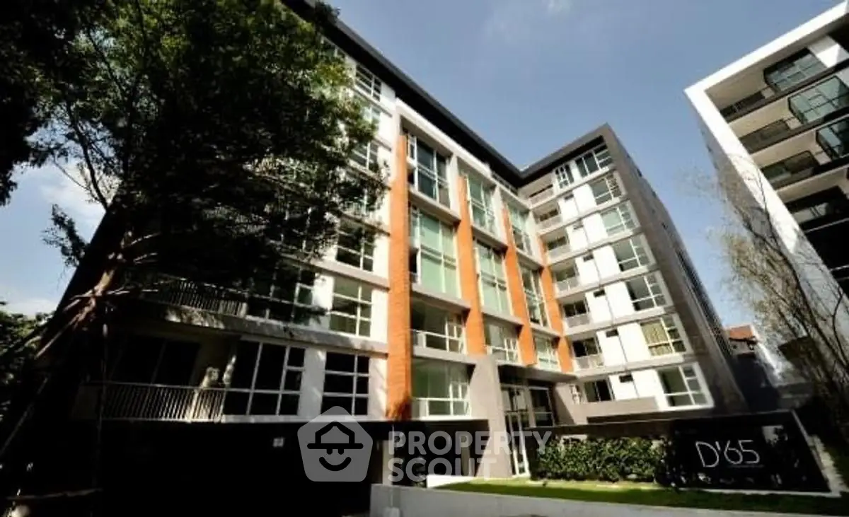 Modern apartment building with sleek design and lush greenery.