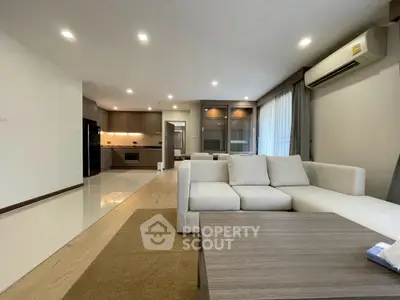 Spacious modern living room with open kitchen and elegant furnishings in a contemporary apartment.