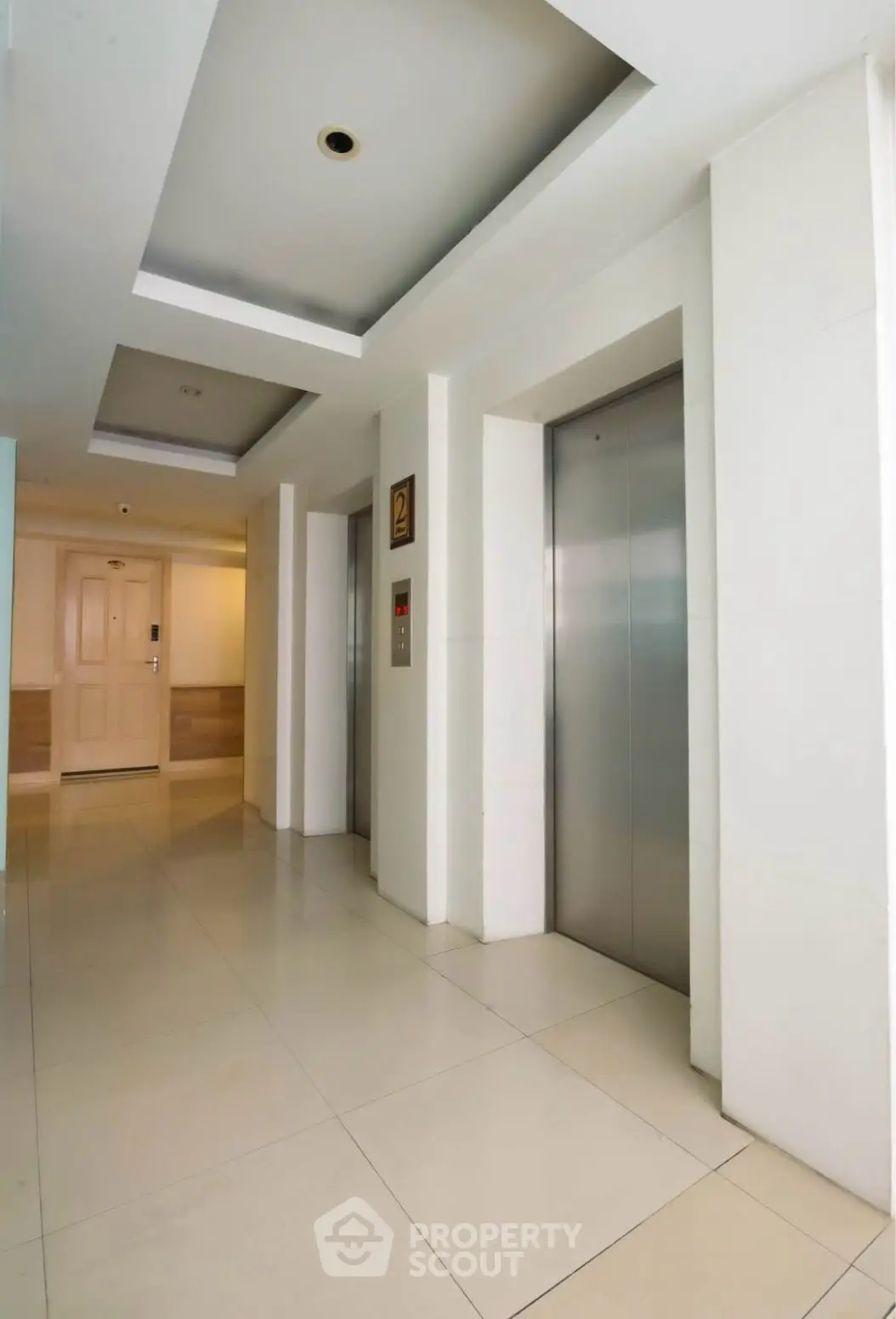 Modern building corridor with sleek elevator doors and stylish ceiling design.