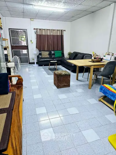 Spacious living room with modern furniture and tiled flooring, perfect for family gatherings.