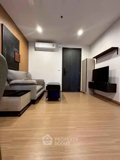 Modern living room with sleek furniture and wooden flooring in a stylish apartment.