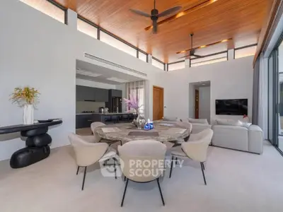 Luxurious modern living room with high ceilings, elegant furniture, and open kitchen layout.