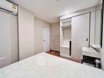 Modern bedroom with built-in wardrobe and air conditioning in a cozy apartment.
