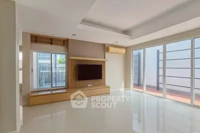 Spacious modern living room with large windows and built-in TV unit