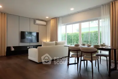 Spacious modern living room with large windows and elegant dining area