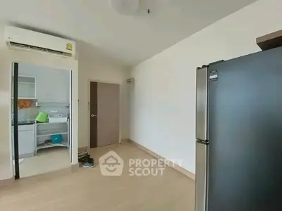 Modern apartment with sleek fridge and air conditioning, showcasing minimalist design.