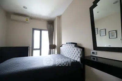 Modern bedroom with stylish decor and natural light, featuring a plush bed and sleek furniture.