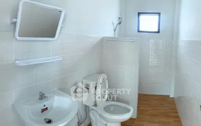 Modern bathroom with white tiles and wooden flooring