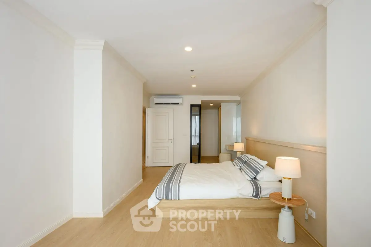 Spacious modern bedroom with elegant wooden flooring and stylish decor