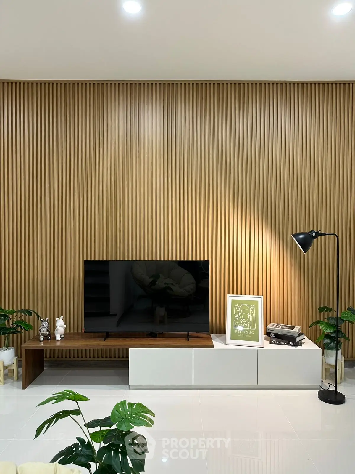 Modern living room with sleek TV stand, wooden panel wall, and stylish decor.