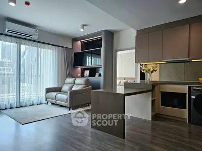 Modern open-layout living room with sleek kitchen and natural light