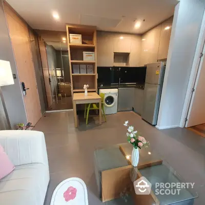 Modern apartment interior with open kitchen, washing machine, and stylish living area