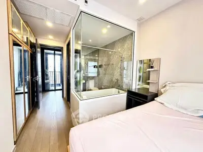 Modern bedroom with glass-walled bathroom and sleek design