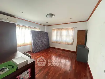 Spacious empty room with hardwood floors and natural light