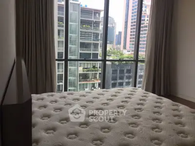 Spacious bedroom with large windows offering a stunning city view