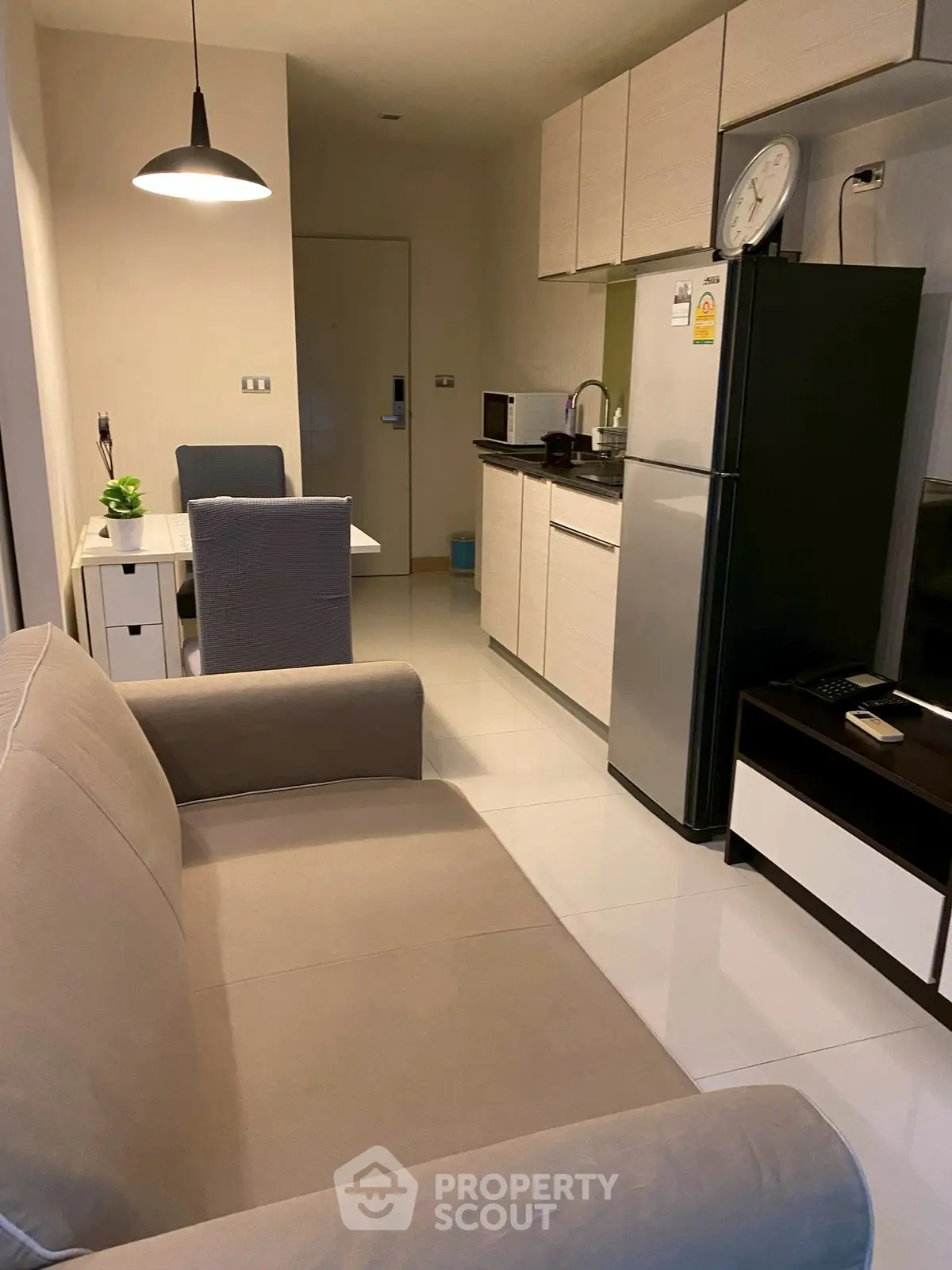 Modern apartment interior with cozy living area and compact kitchen, featuring sleek furniture and contemporary design.