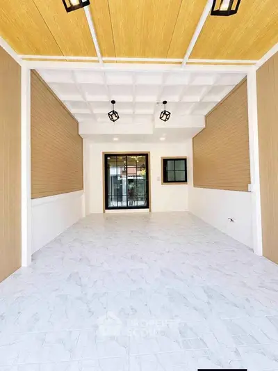 Spacious modern interior with elegant ceiling lights and large windows, perfect for versatile living space.
