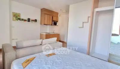 Modern studio apartment with compact kitchen and cozy living area, ideal for urban living.