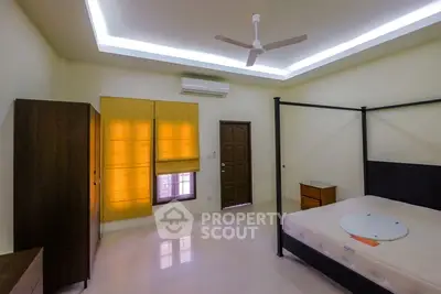 Spacious bedroom with modern ceiling fan and ample natural light