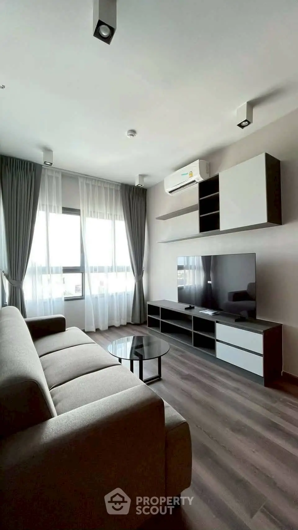 Modern living room with sleek furniture and large windows offering natural light.