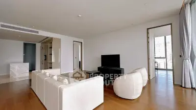 Spacious modern living room with elegant furniture and city view balcony.