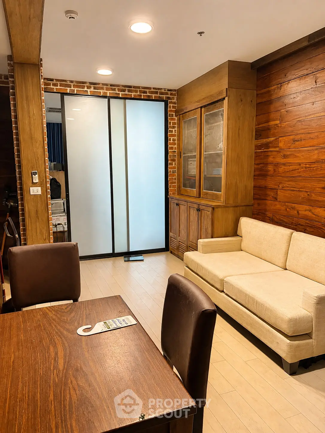 Charming living room with wooden accents and frosted glass doors, perfect for cozy gatherings.