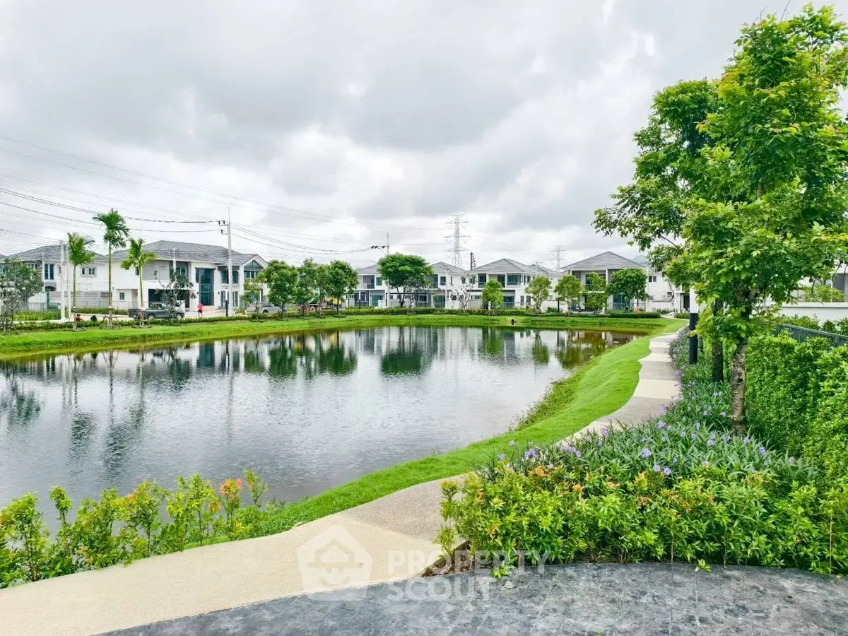 Scenic view of residential community with serene pond and lush greenery