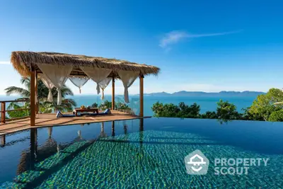 Luxurious infinity pool with ocean view and elegant cabana in tropical paradise.