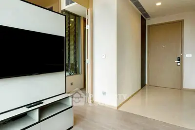 Modern apartment entrance with sleek TV unit and wooden flooring
